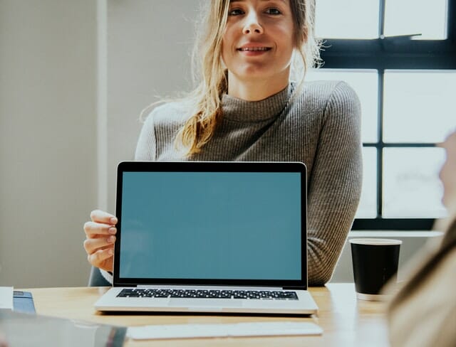 woman smiling behind a computer