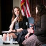 Andia Dinesen, AFC, speaking with a colleague at a live conference