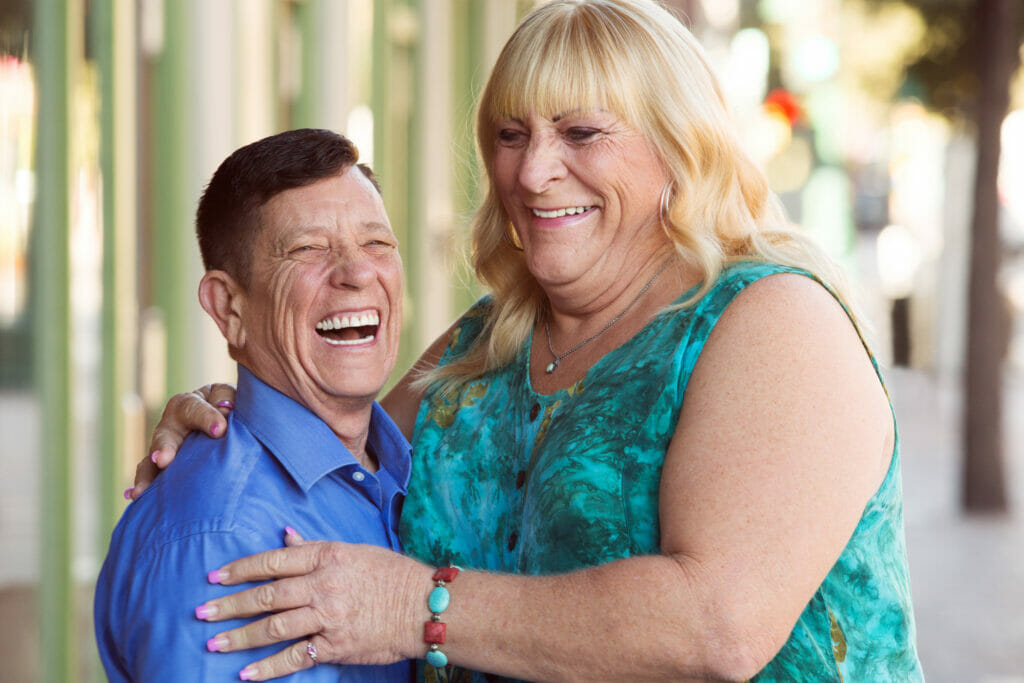 embracing couple smiling at the camera