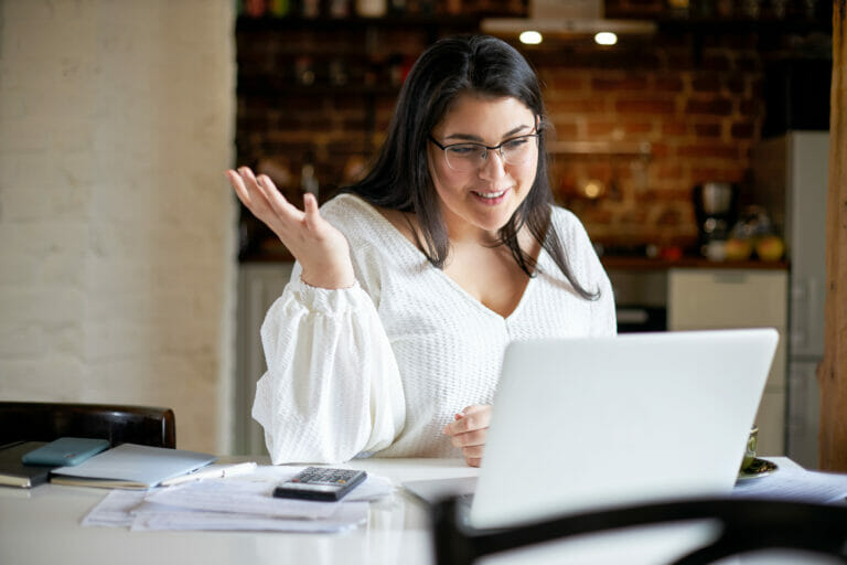 Woman speaking to someone on a video call on a laptop