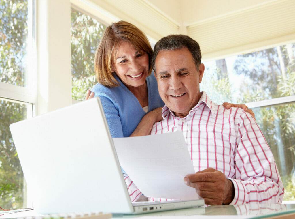 Smiling couple reviewing a document.