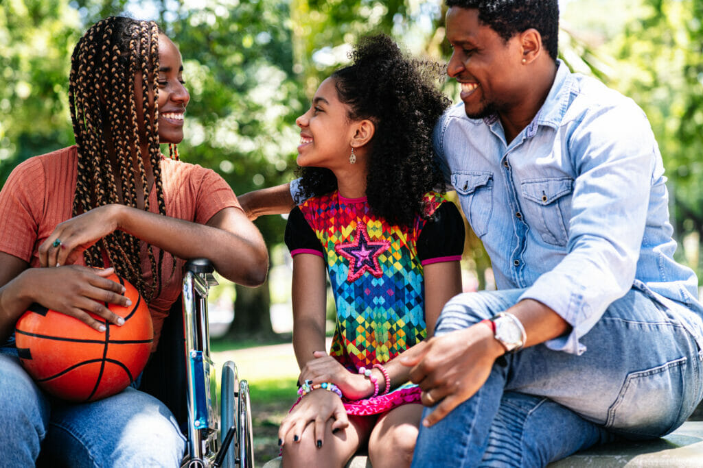 Woman in a wheelchair at the park with family.