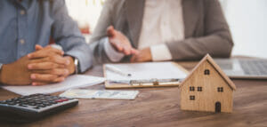 Two people signing an agreement to purchase a home