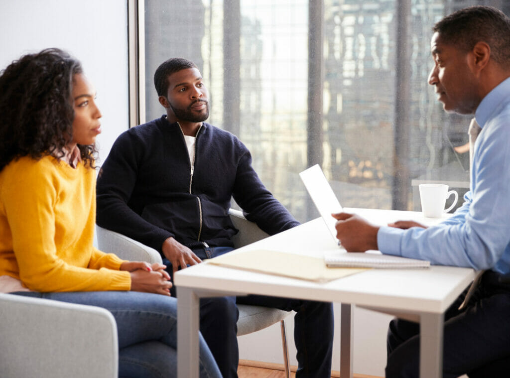 A Black couple meets with a financial counselor