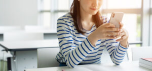 Young asian female student using a smart phone.