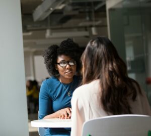 Two women talking to each other in an office setting