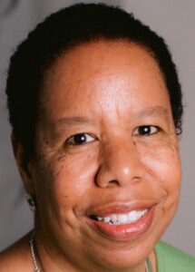 headshot of black woman smiling with short black hair wearing a green shirt