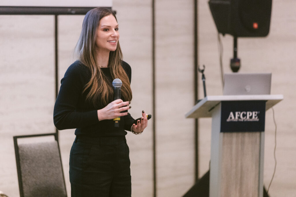 white woman standing in front of podium at Symposium