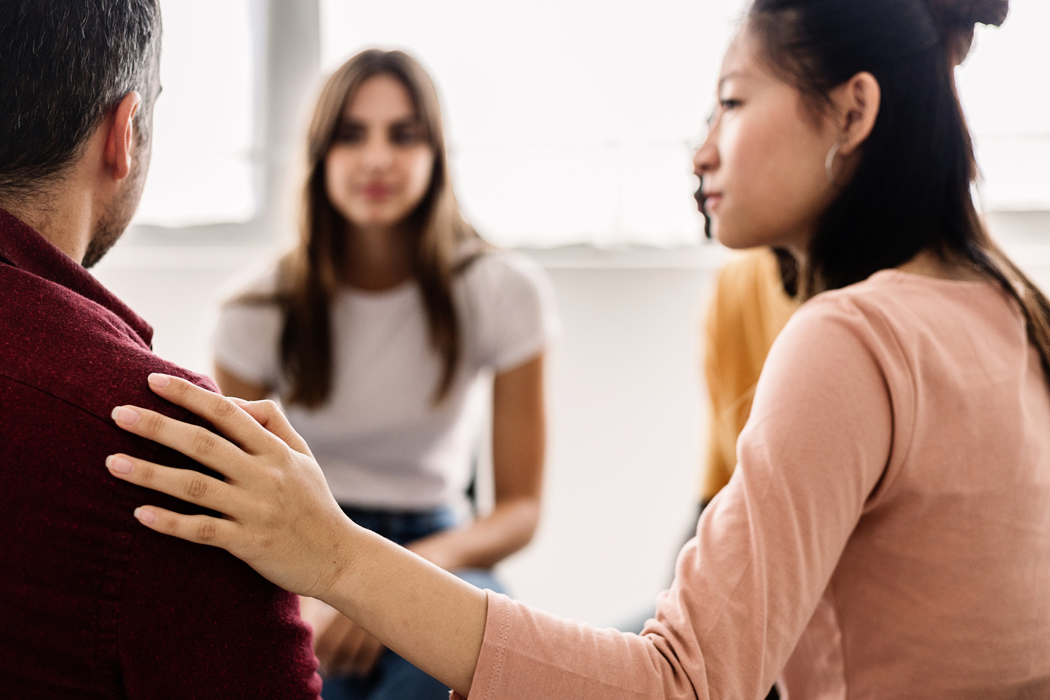 Diverse young people receiving support during a therapy session.