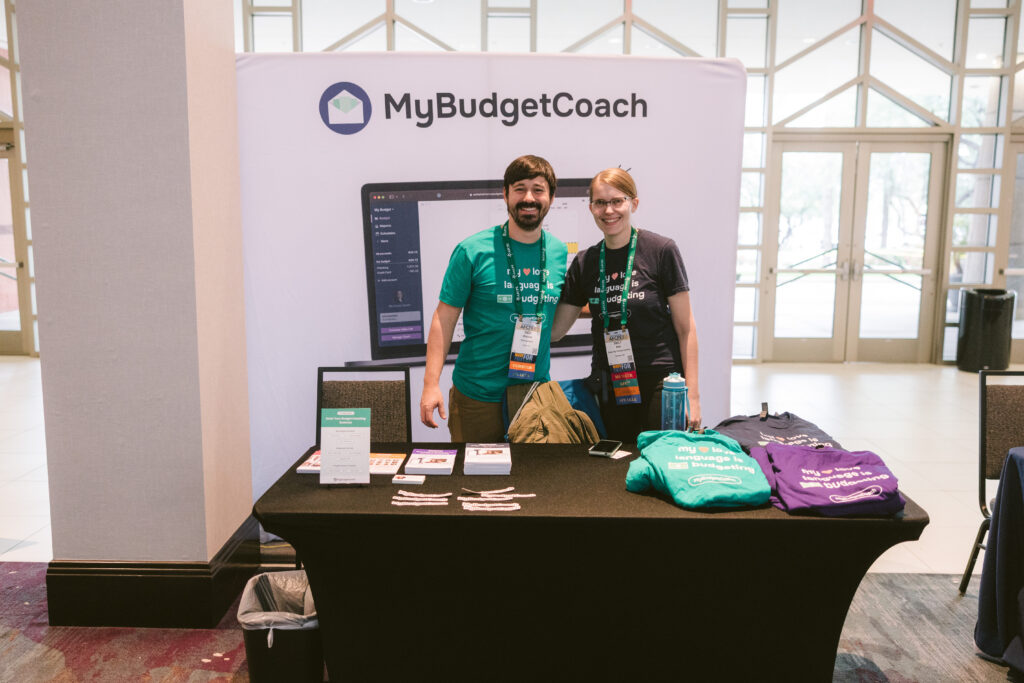 A man and woman exhibiting for their business My Budget Coach at Symposium