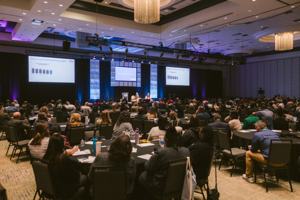 wide view of the ballroom with hundreds of attendees at Symposium