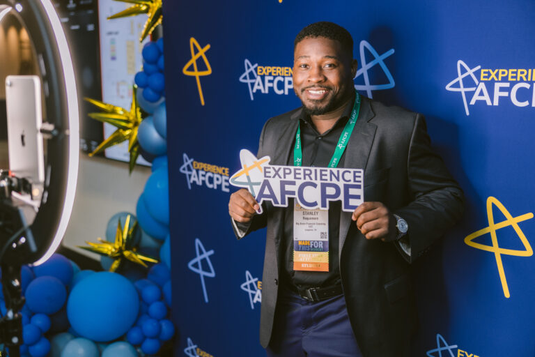 A photo of a man holding up an "Experience AFCPE" sign.