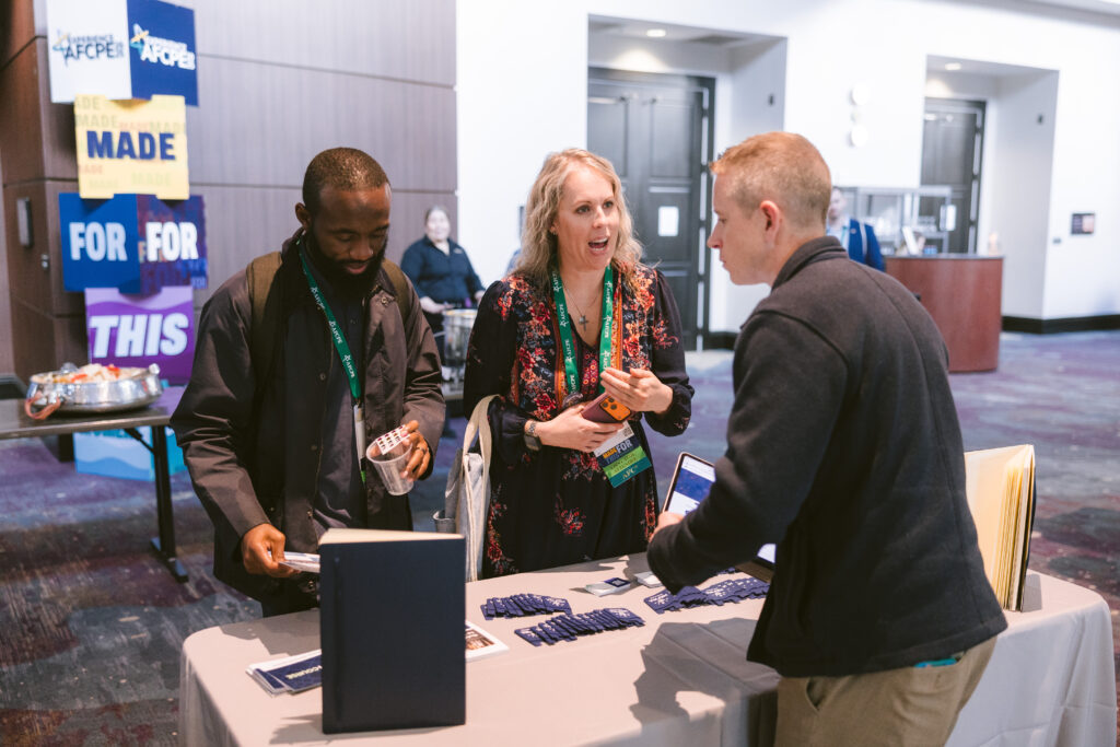 Three people discussing their services at Symposium