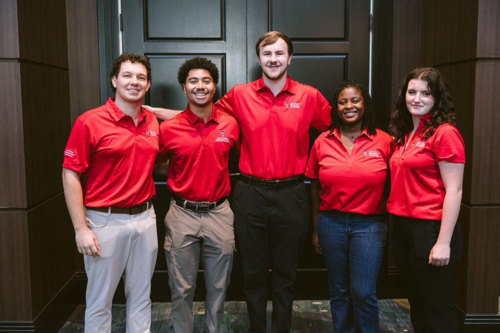 five college aged men and women in matching red shirts at Symposium