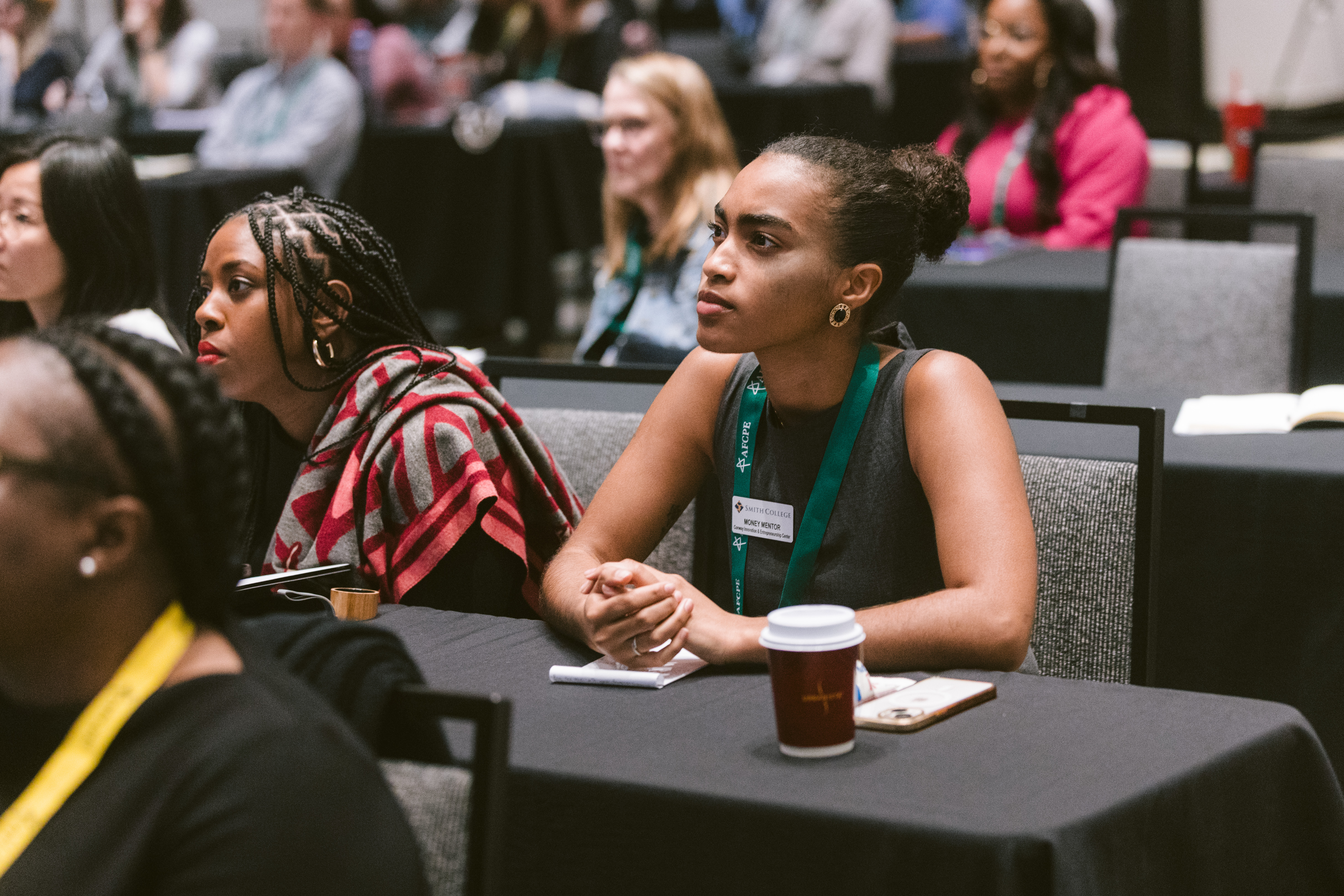 Woman of color taking notes at Onsite Review at Symposium
