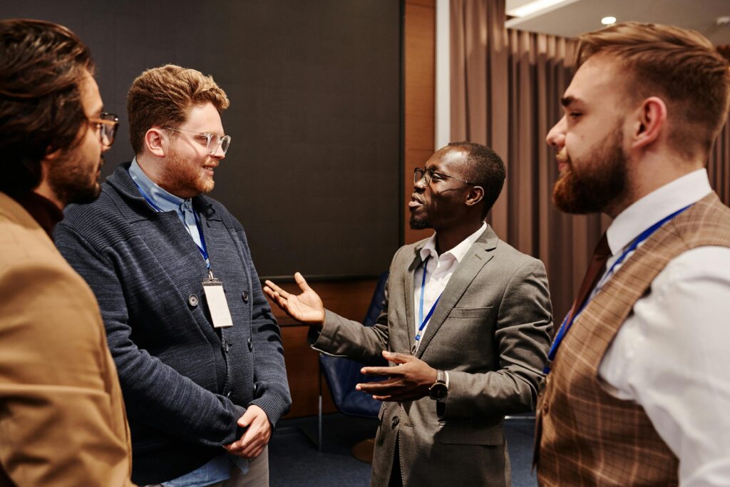 Four men in a room professionally dressed networking in a conference room