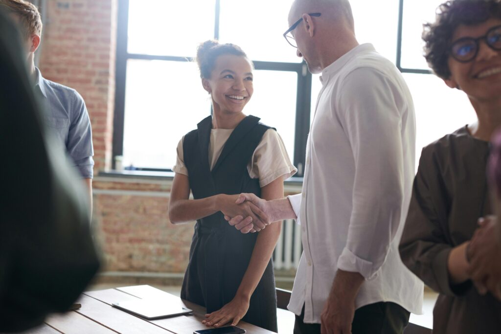Man and woman on a team shaking hands after a project ends