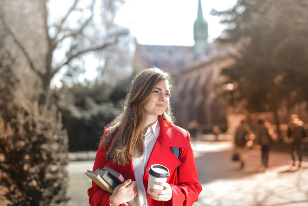 A woman student in a red blazer on a college campus