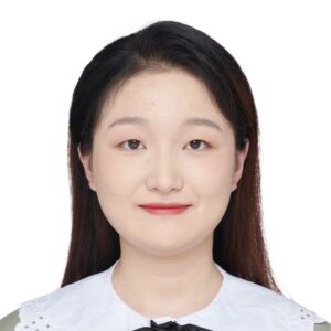 headshot of an asian woman with long black hair and slight smile wearing a white shirt amid a white backdrop
