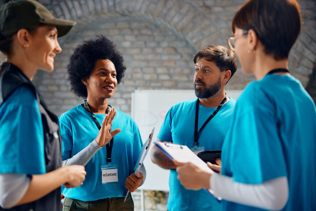 Multiracial group of volunteers talking while working at community center.