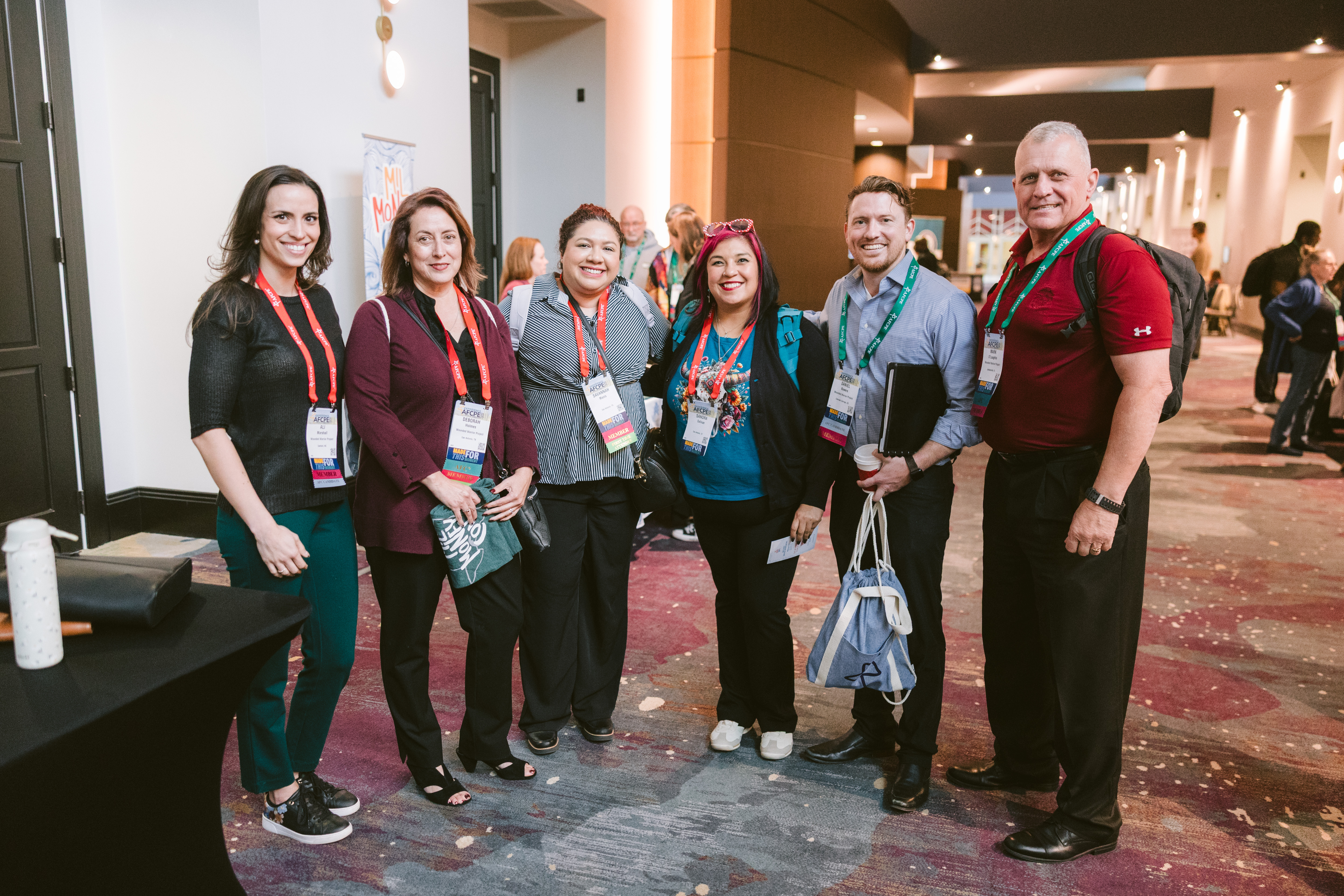 group of smiling men and women in the hall at Symposium