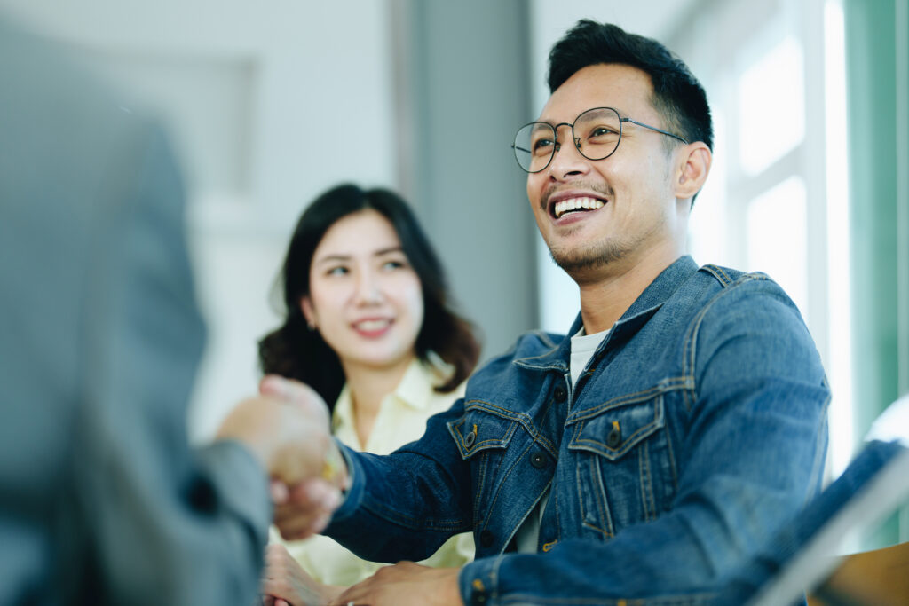 happy client shakes hands with financial counselor after a meeting