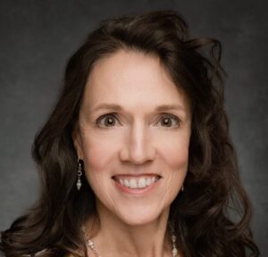 headshot of white woman with long brown hair smiling