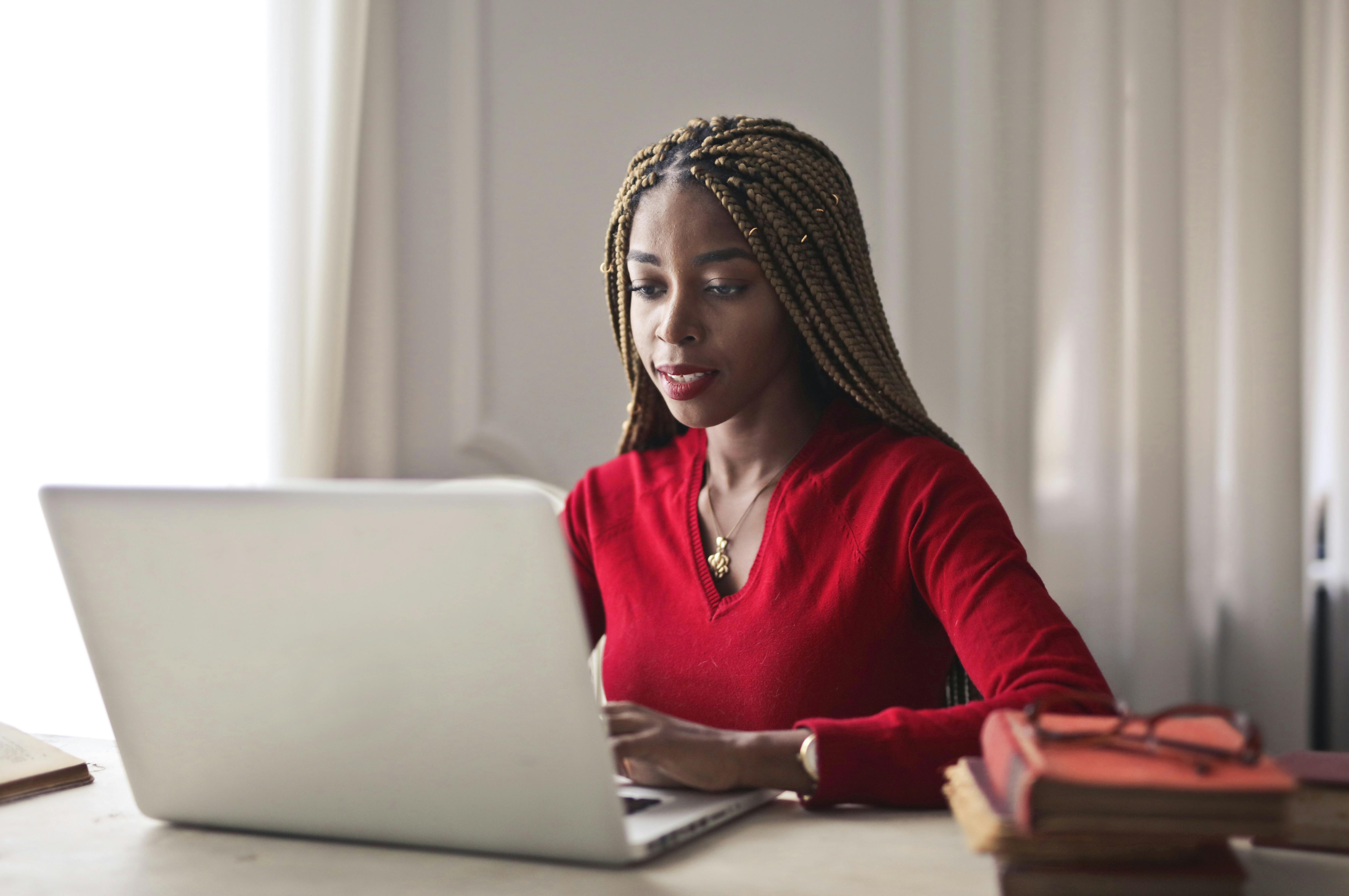 Black woman in home office doing research online