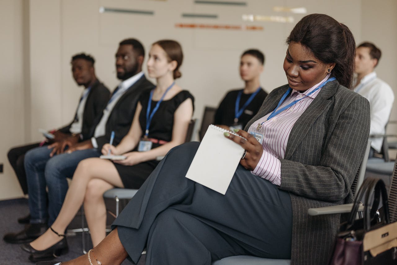 professional black woman taking notes in a diverse classroom