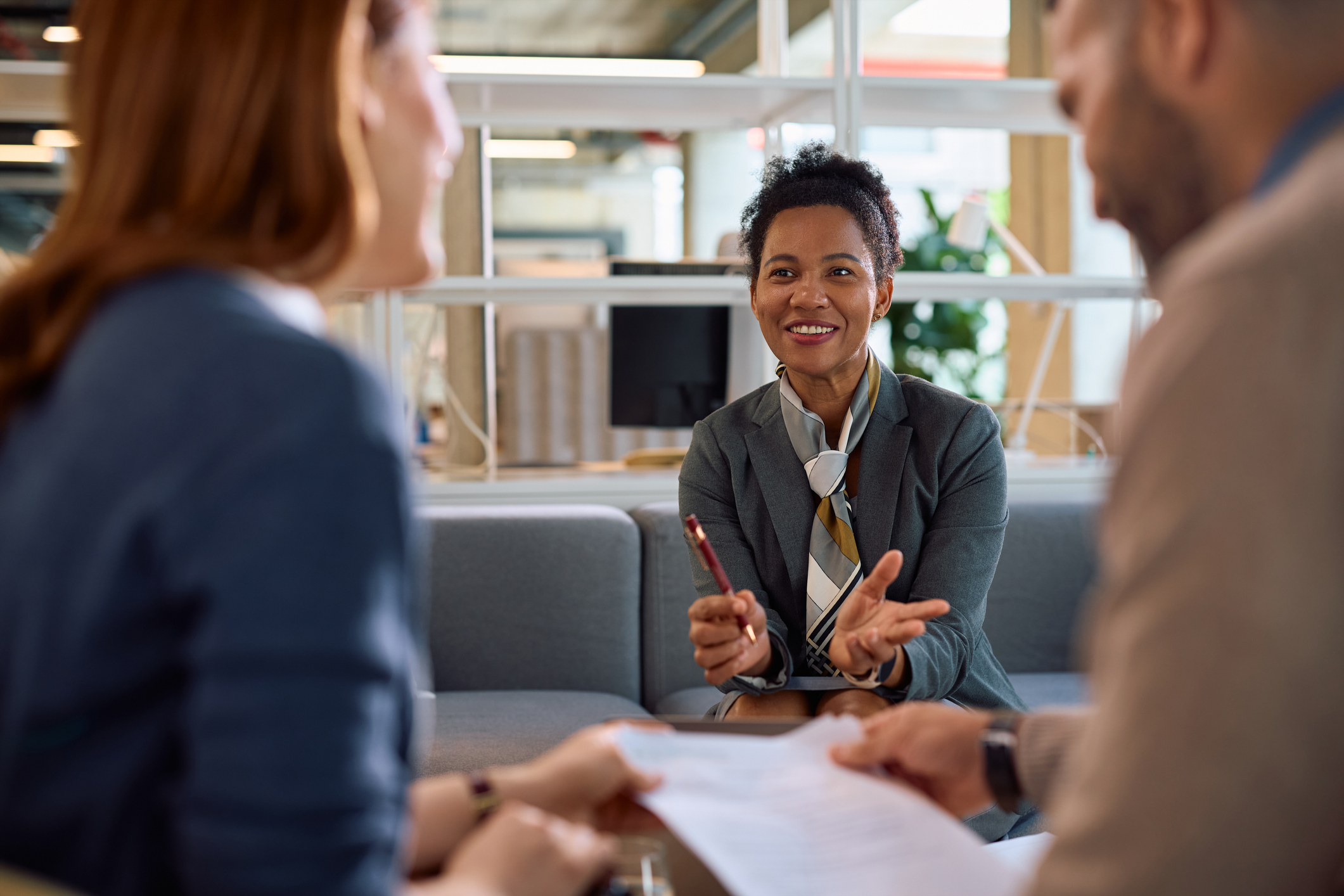 Happy black financial consultant having a meeting with her clients in the office.