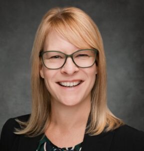 Headshot of woman with blonde hair and glasses.