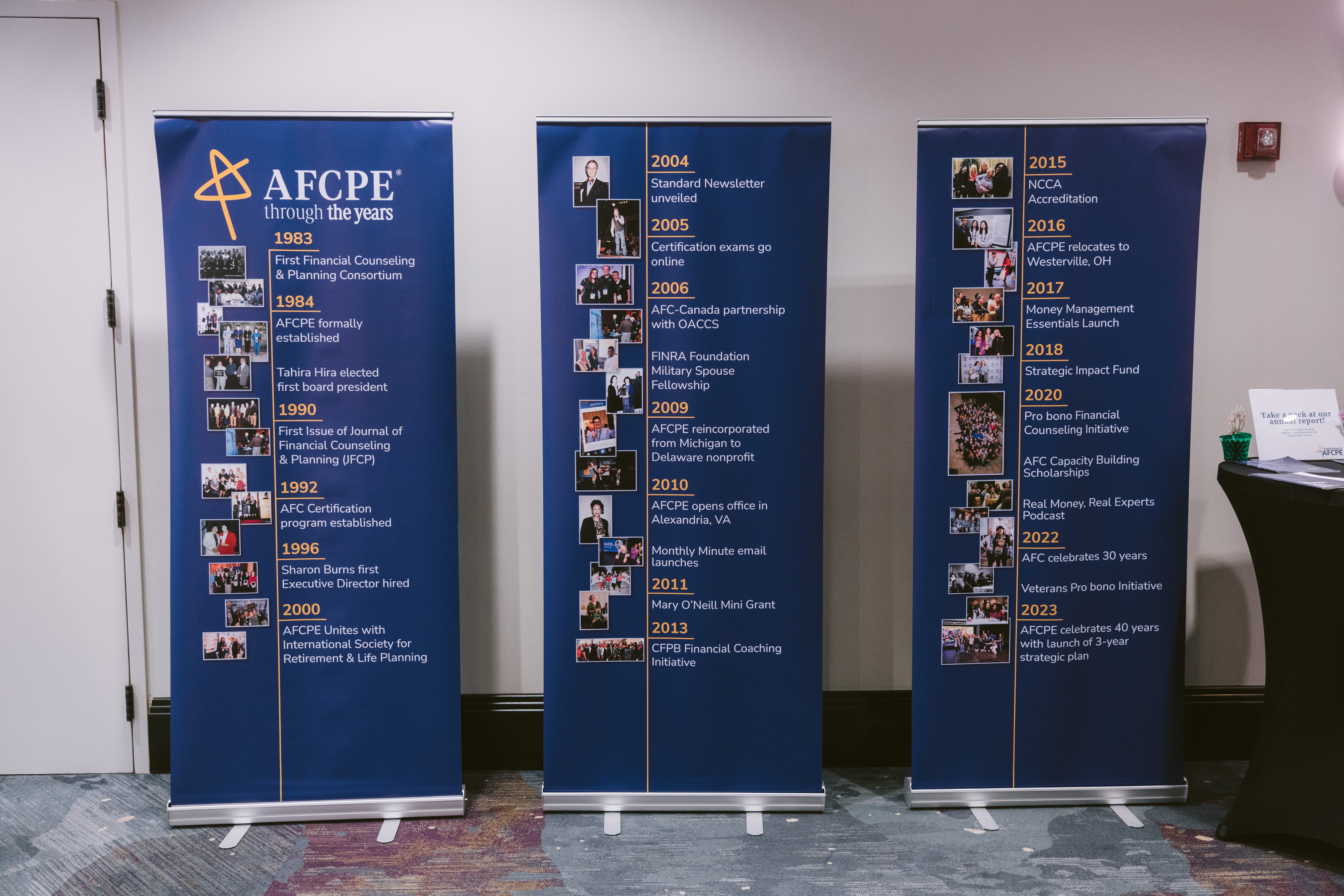 three blue poster boards that represent the AFCPE timeline of milestones