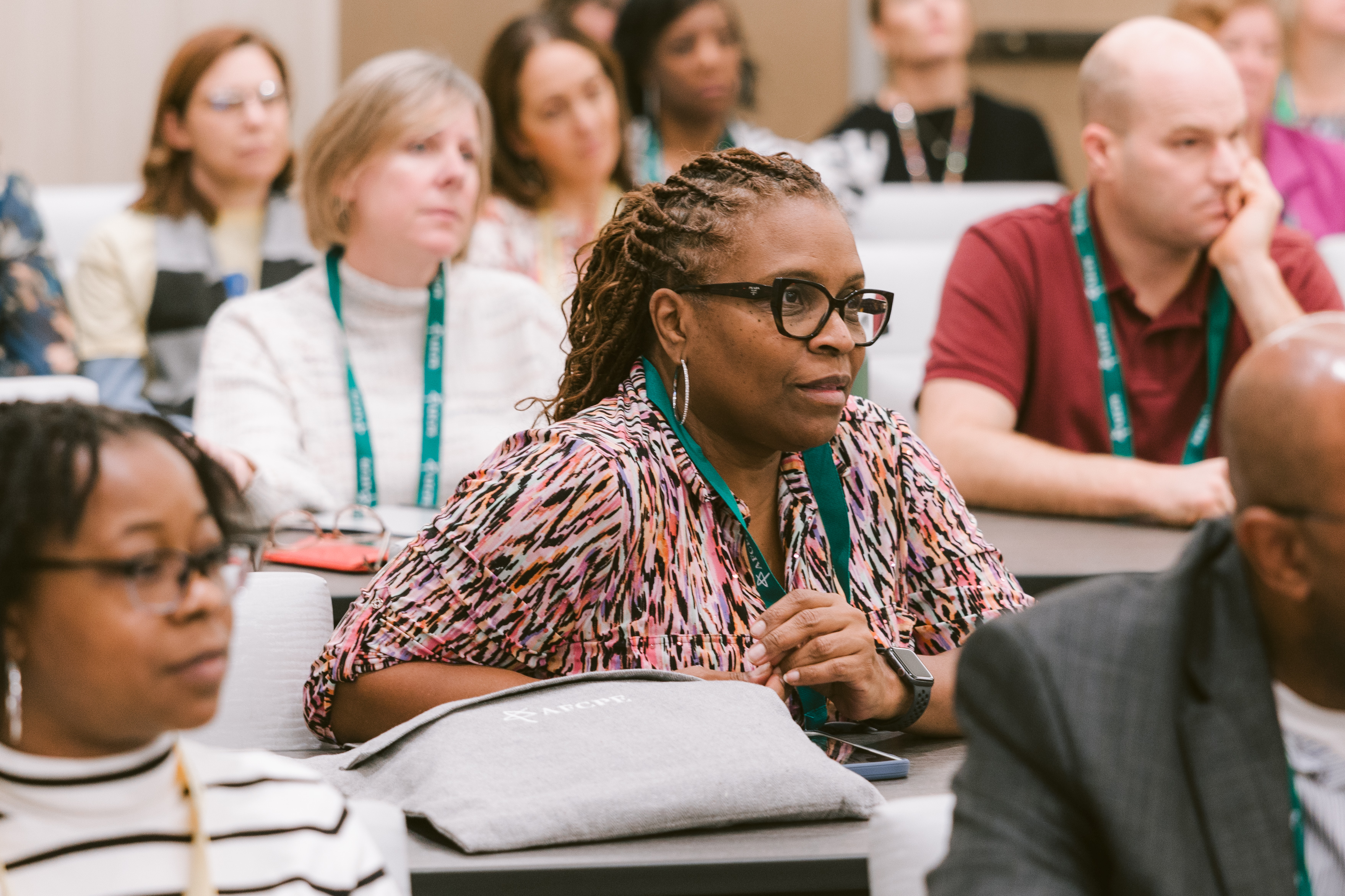 diverse group of serious professionals listening to a presentation