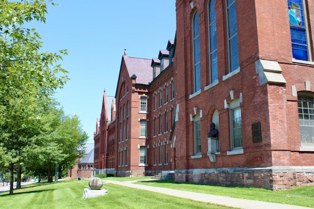 The exterior of brick academic building and it's lawn filled campus