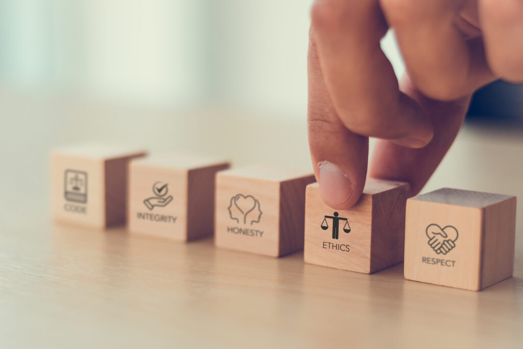Code of conduct in business concept. Wooden blocks with code of conduct icons; code, integrity, honesty, respect, and ethics, the foundation of a strong corporate code of conduct. Corporate ethics.