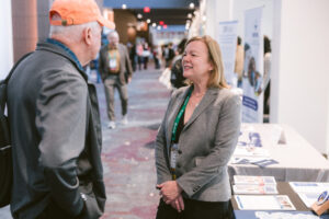 A FINRA employee talking to a Symposium attendee.
