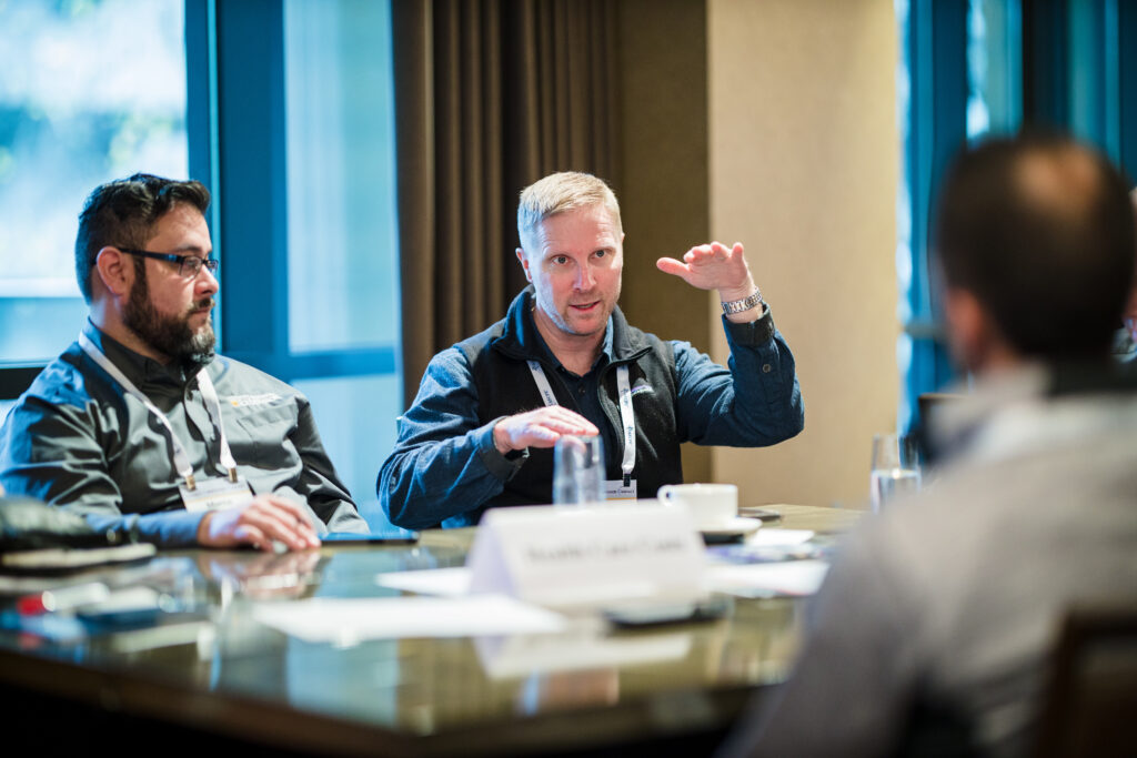 Three men having an intense roundtable conversation during a meeting.