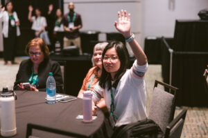 Photo of a woman raising her hand.