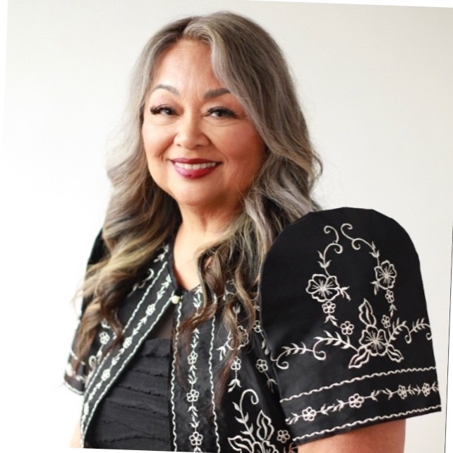 asian woman with long grey hair smiling with a white background