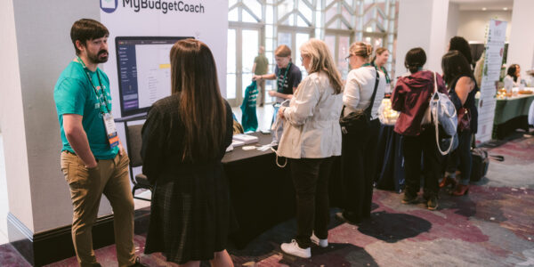 people stopping at the exhibit booth at Symposium