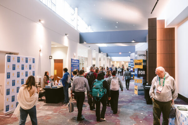 Crowd of people networking in the halls of Symposium.