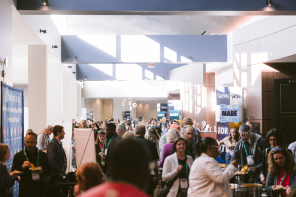 Crowd of people networking in the halls of Sympsium