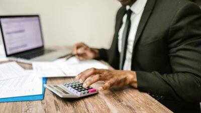 black man in black suit calculating taxes